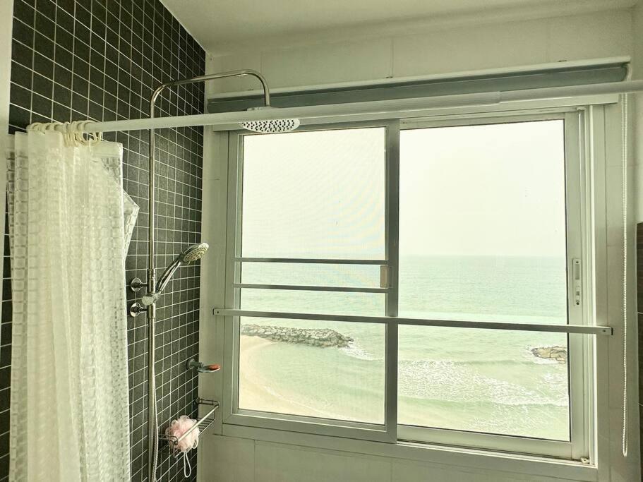 eine Dusche mit einem Fenster mit Meerblick in der Unterkunft บ้านชายทะเล ที่พักติดทะเล ระยอง หาดแสงจันทร์ in Rayong