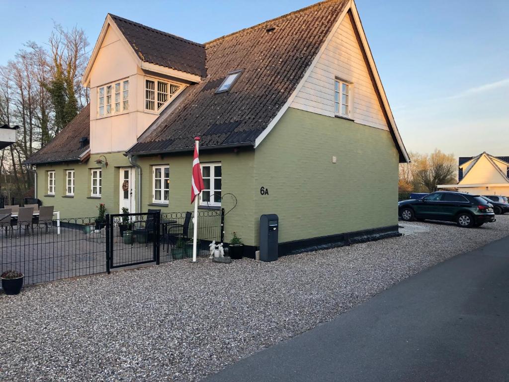 een groen huis met een vlag ervoor bij Brønks Bed and Breakfast in Langeskov