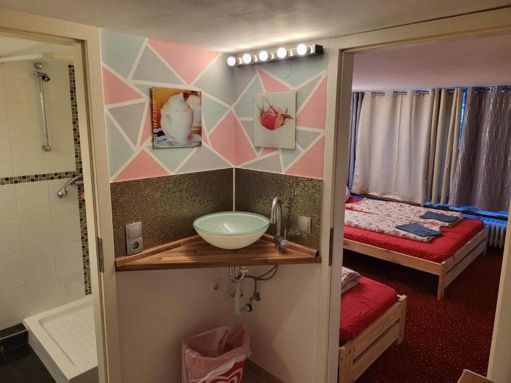 a bathroom with a sink and a room with a bed at Hostel Hamburg in Hamburg