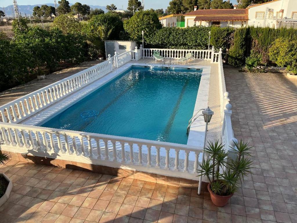 una piscina con una valla blanca alrededor en La casa de mamá, en Lorca