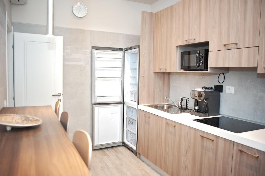 羅馬的住宿－SCIPIO92HOME，厨房配有木制橱柜和木桌。