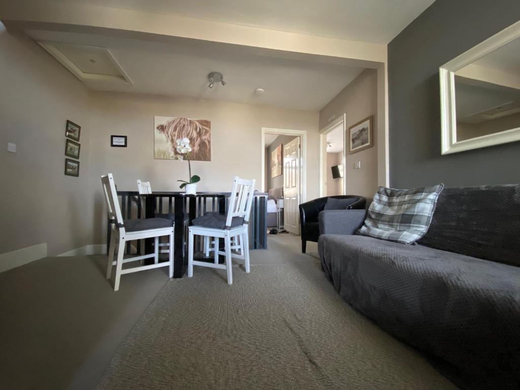 Eclipse Apartment No 2 في نيوماركت: غرفة معيشة مع أريكة وطاولة وكراسي