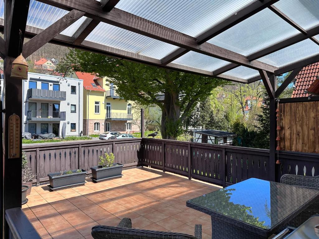 un patio con pérgola, mesa y sillas en Schöne Altbauwohnung mit großer Sonnenterrasse, en Rudolstadt