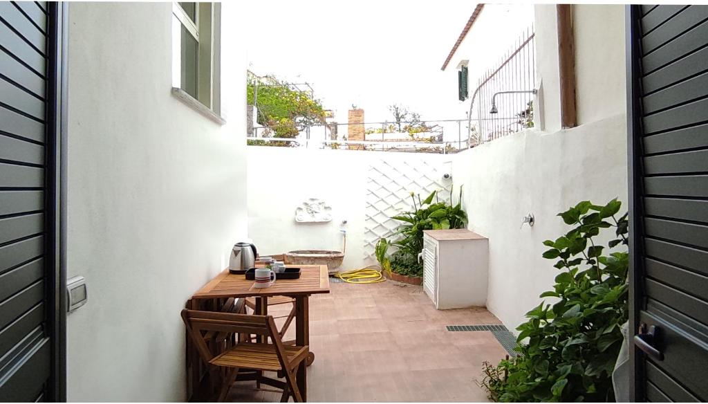 eine kleine Terrasse mit einem Tisch und Stühlen auf dem Balkon in der Unterkunft La Romantique in Anacapri