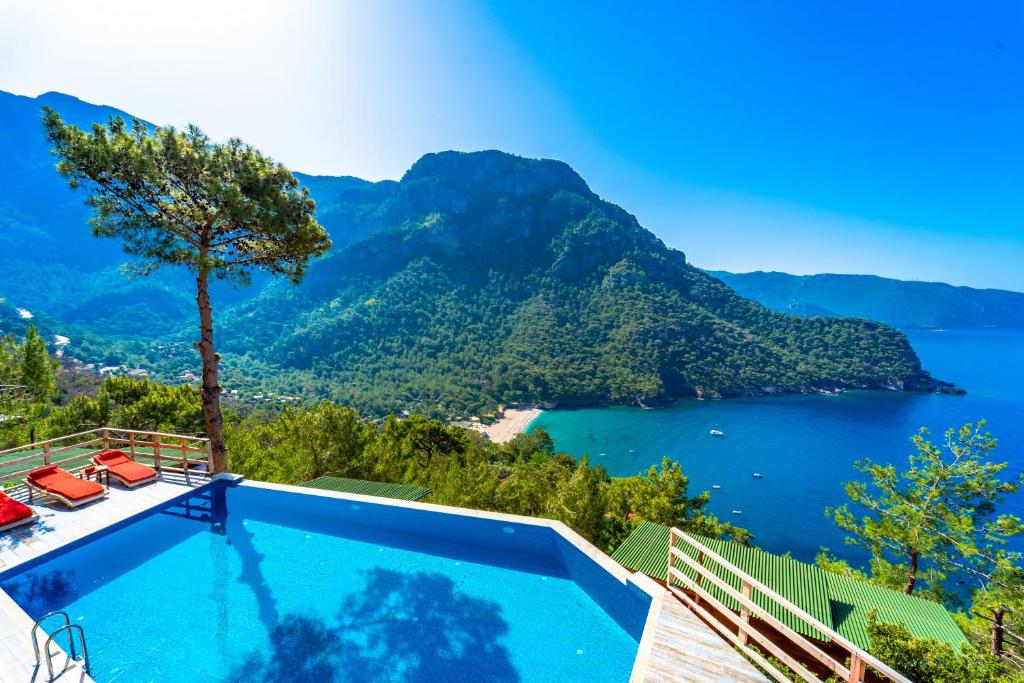 uma piscina com vista para um lago e montanhas em Manzara Bungalov em Fethiye