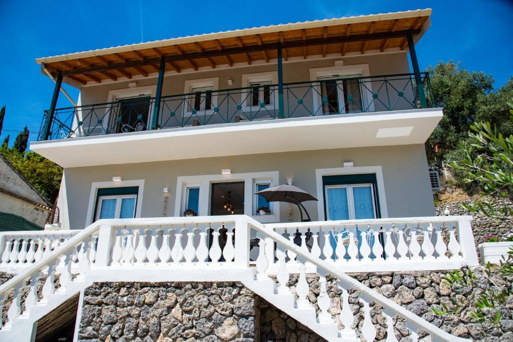Cette maison blanche dispose d'un balcon et d'un escalier. dans l'établissement Nausika Rustic Cottage, à Paleokastritsa