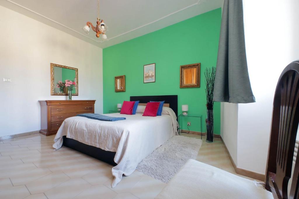 ローマにあるCasa Rossi Romaの緑の壁、ベッド付きのベッドルーム1室
