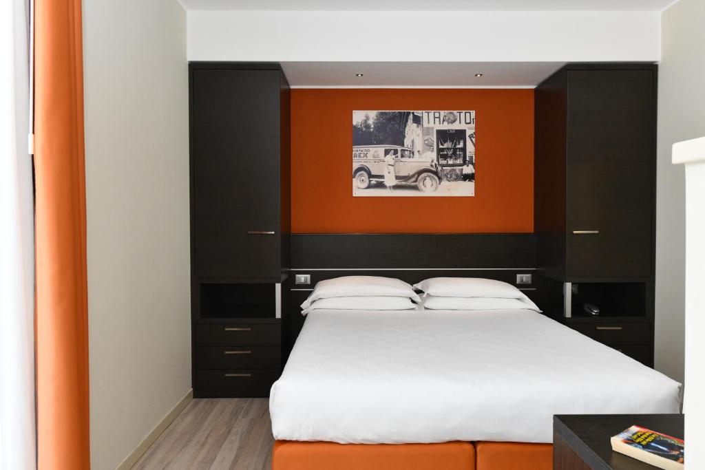 1 dormitorio con 1 cama con cabecero naranja y negro en Hotel Vienna en Lido di Jesolo
