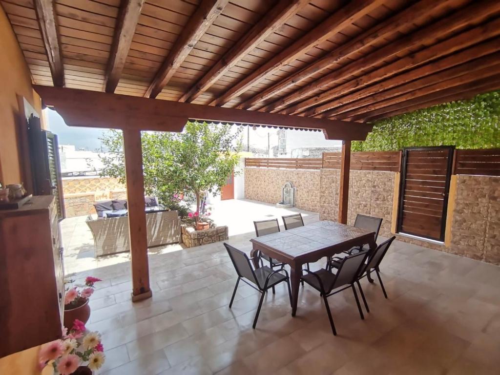 a patio with a wooden pergola and a table and chairs at Archangelos House in Archangelos