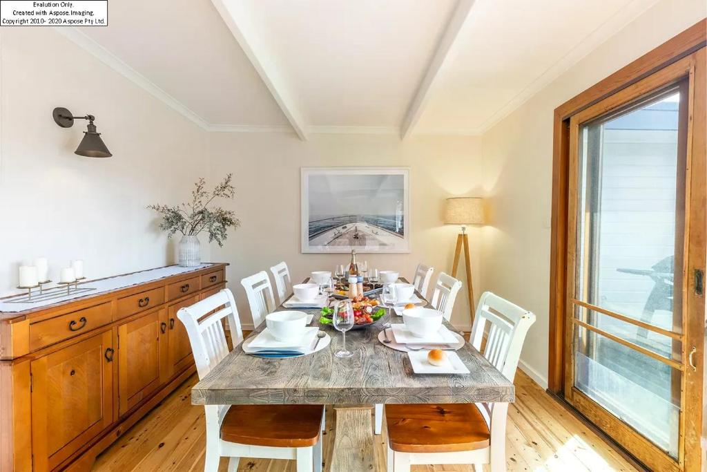 a dining room with a table and white chairs at Entire Nelson Bay home walk to the Beach and Town Centre in Nelson Bay