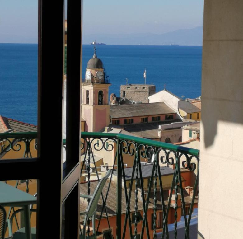 une vue depuis un balcon d'un immeuble avec une tour d'horloge dans l'établissement IL VELIERO, à Camogli