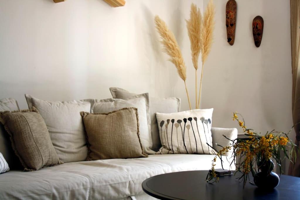 a living room with a white couch and a table at Cosy Cave Apartment by the sea in Loutraki