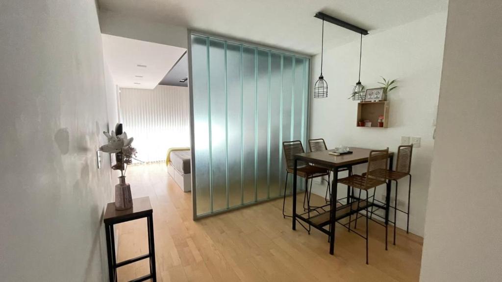 a dining room with a table and chairs and a glass wall at Espectacular en lo mejor de Belgrano sobre Libertador in Buenos Aires
