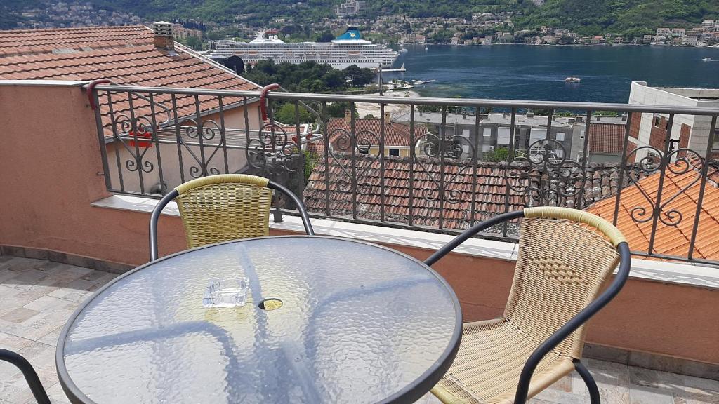 un tavolo in vetro e 2 sedie sul balcone di Apartments Krivokapic Kotor a Kotor (Cattaro)