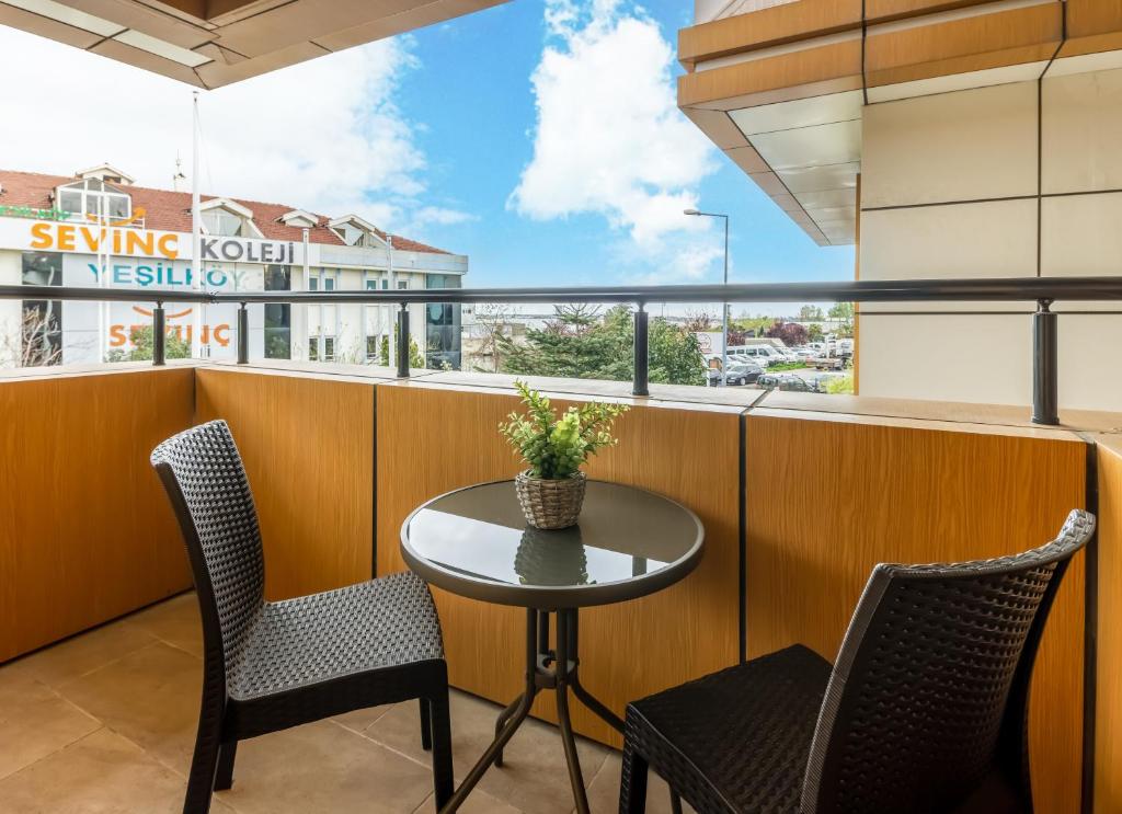a small table and chairs on a balcony with a window at Baymari Suites Design Florya in Istanbul