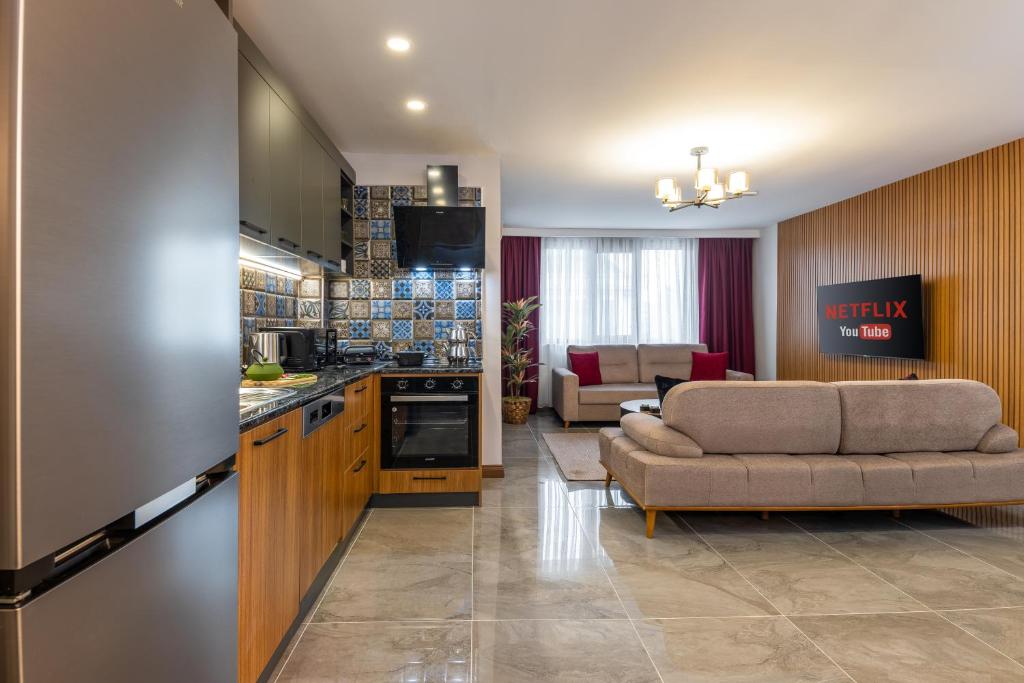 a kitchen and a living room with a couch and a table at Baymari Suites Design Florya in Istanbul
