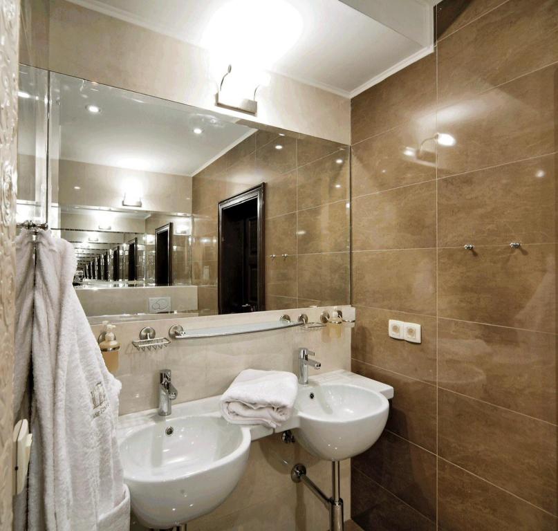 ein Bad mit einem Waschbecken und einem Spiegel in der Unterkunft PARKOVY apart in Truskawez