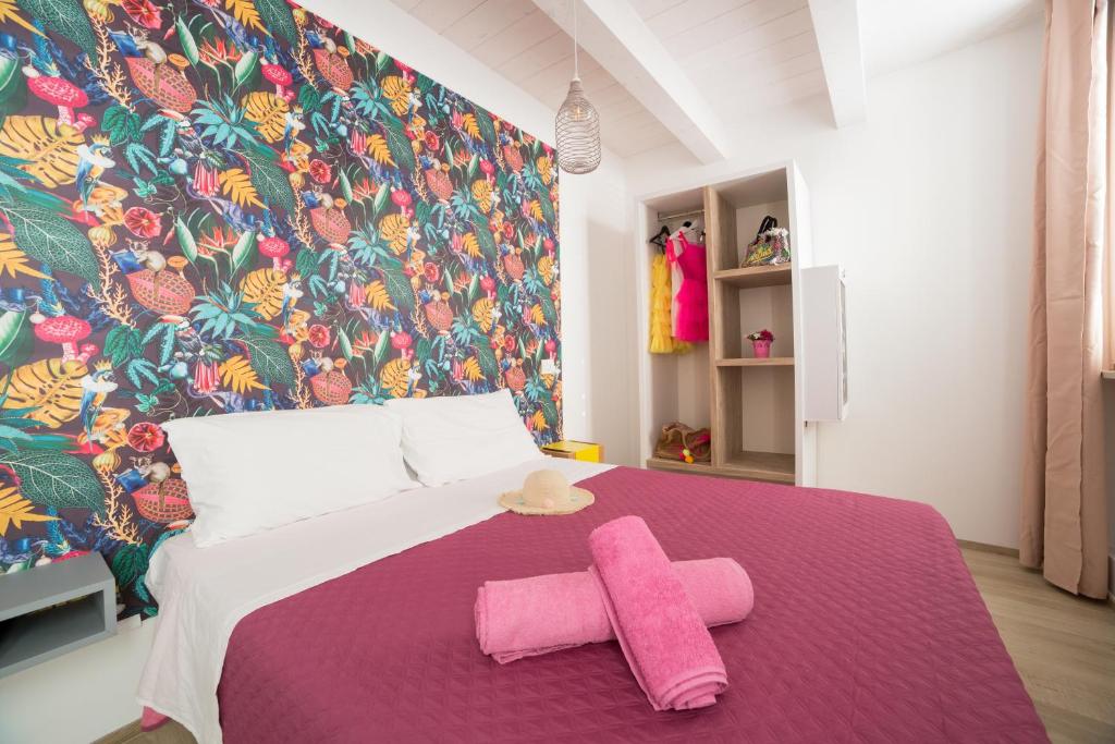 una camera da letto con un letto con due asciugamani rosa di retroscena matrimoniale in centro a Civitanova Marche