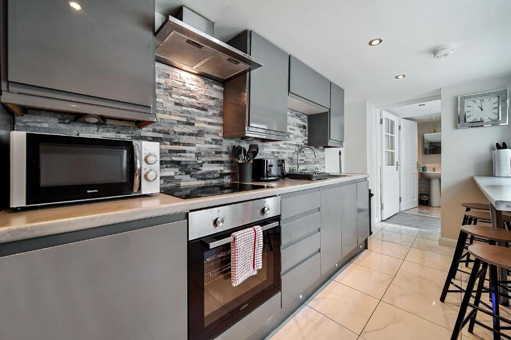 a kitchen with a stove and a microwave at Carlisle Lodge 'Sleeping 6 guests' in Derry Londonderry