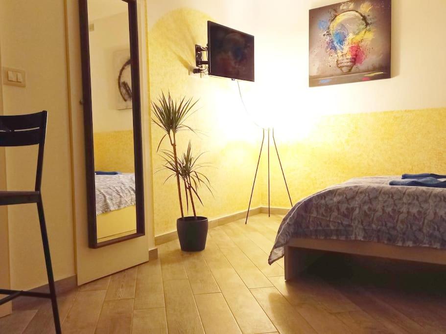 タオルミーナにあるCasa Ponturoのベッドルーム1室(ベッド1台、鏡、植物付)