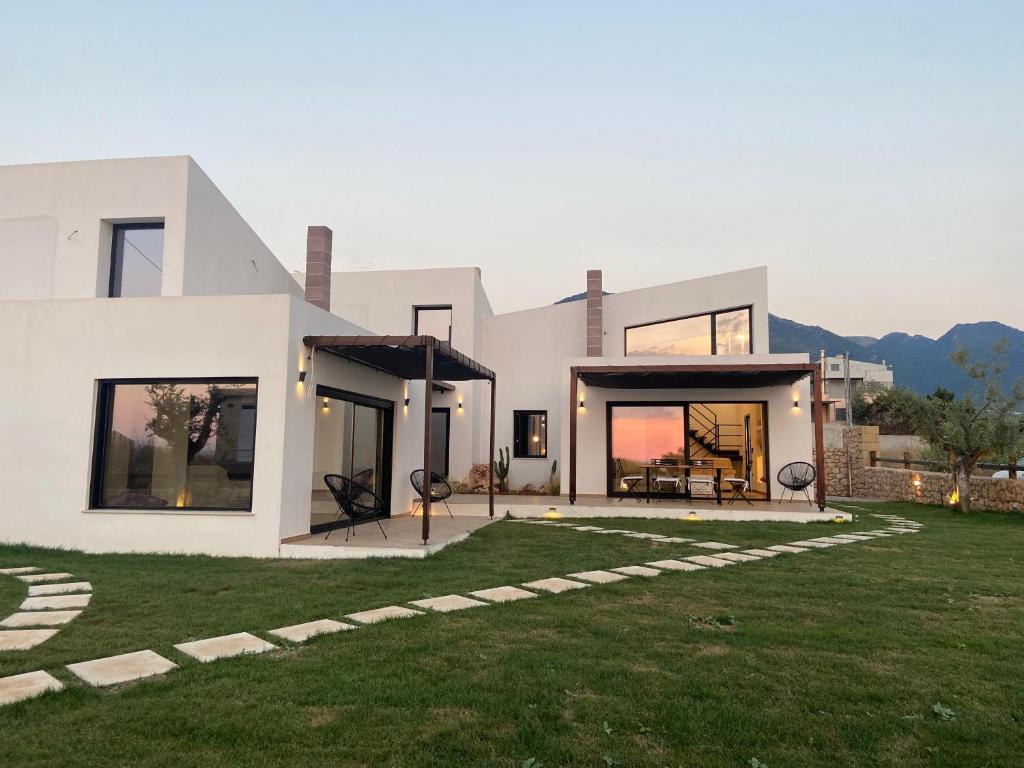 a large white house with a grass yard at OLIVOMARE in Kyparissia