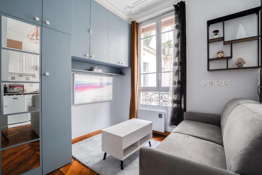 salon z kanapą i stołem w obiekcie Studio rénové cosy metro Paris 2pers wifi w Paryżu
