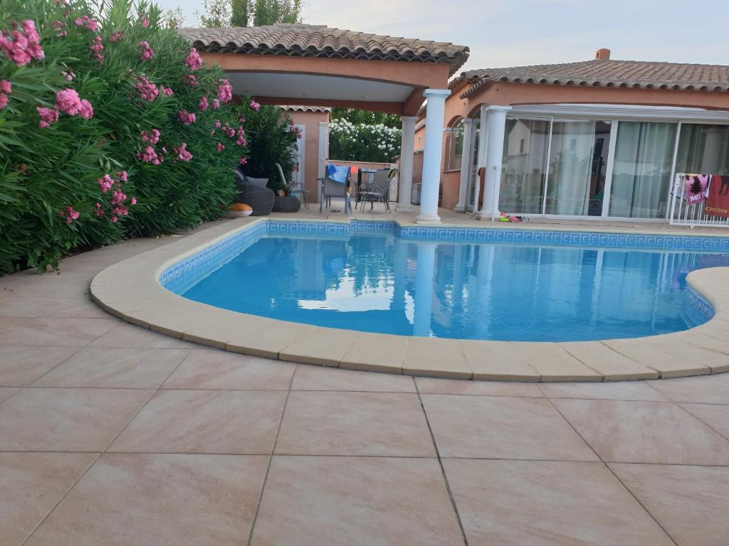 a swimming pool in a yard with a house at Villa plain pied avec piscine privée 8 personnes in La Crau