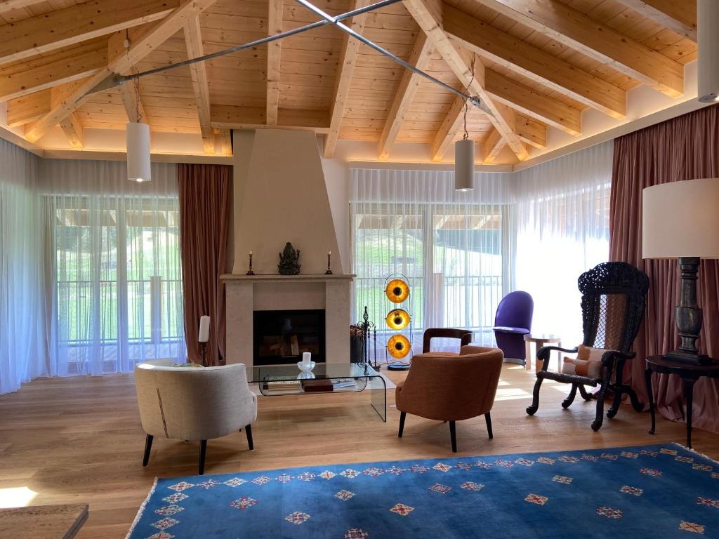 トリンスにあるSmiley-Homes Vegi &Silence Apartmentsの木製の天井と椅子、暖炉付きのリビングルーム