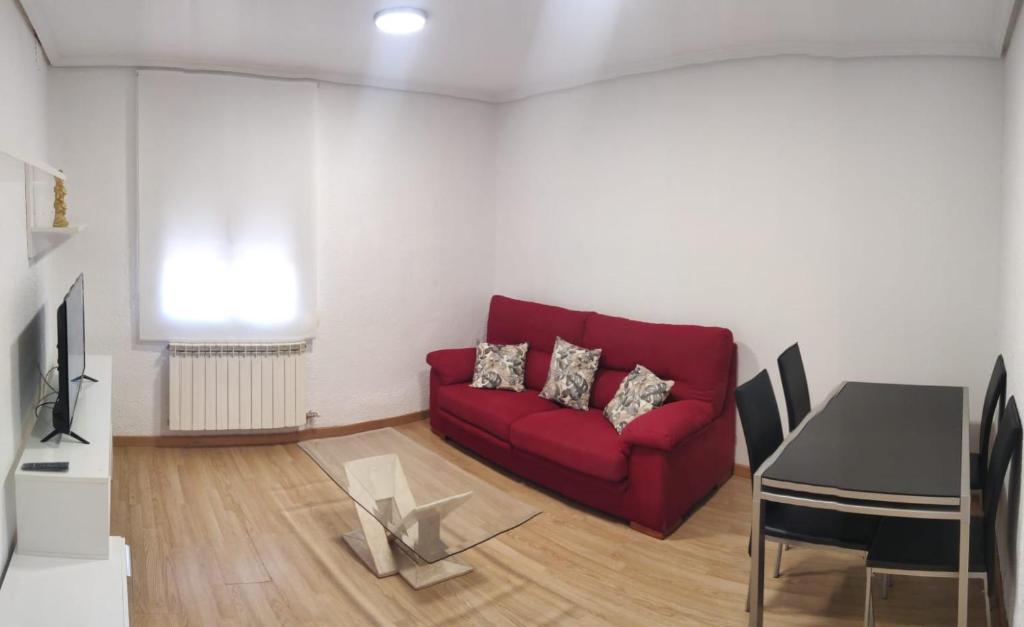 sala de estar con sofá rojo y mesa en Amplio apartamento con 2 baños en Logroño