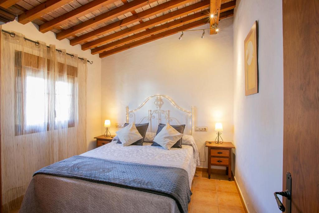 ein Schlafzimmer mit einem Bett mit blauen Laken und einem Fenster in der Unterkunft Apartamento La Mesta, Facinas - Tarifa in Facinas