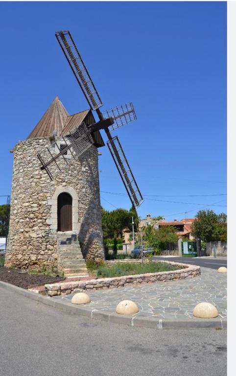 a stone windmill sitting on the side of a road at Appart 30 m2 cosy 2 personnes 1 grande chambre en mezzanine in Saint-Mitre-les-Remparts