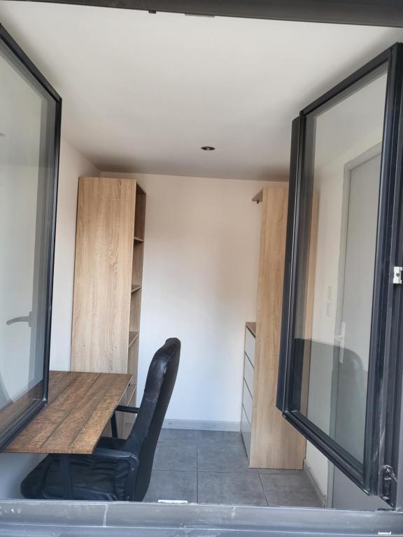 a room with a desk and a chair in it at Appart 30 m2 cosy 2 personnes 1 grande chambre en mezzanine in Saint-Mitre-les-Remparts