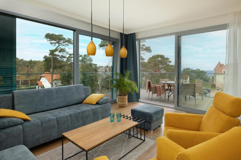 salon z kanapą i stołem w obiekcie Sea&Sky View Apartment Par La Mer w mieście Niechorze