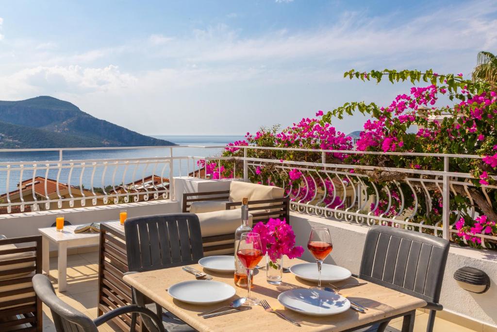 a table on a balcony with a view of the ocean at Korsan Apartment No.16 in Kaş