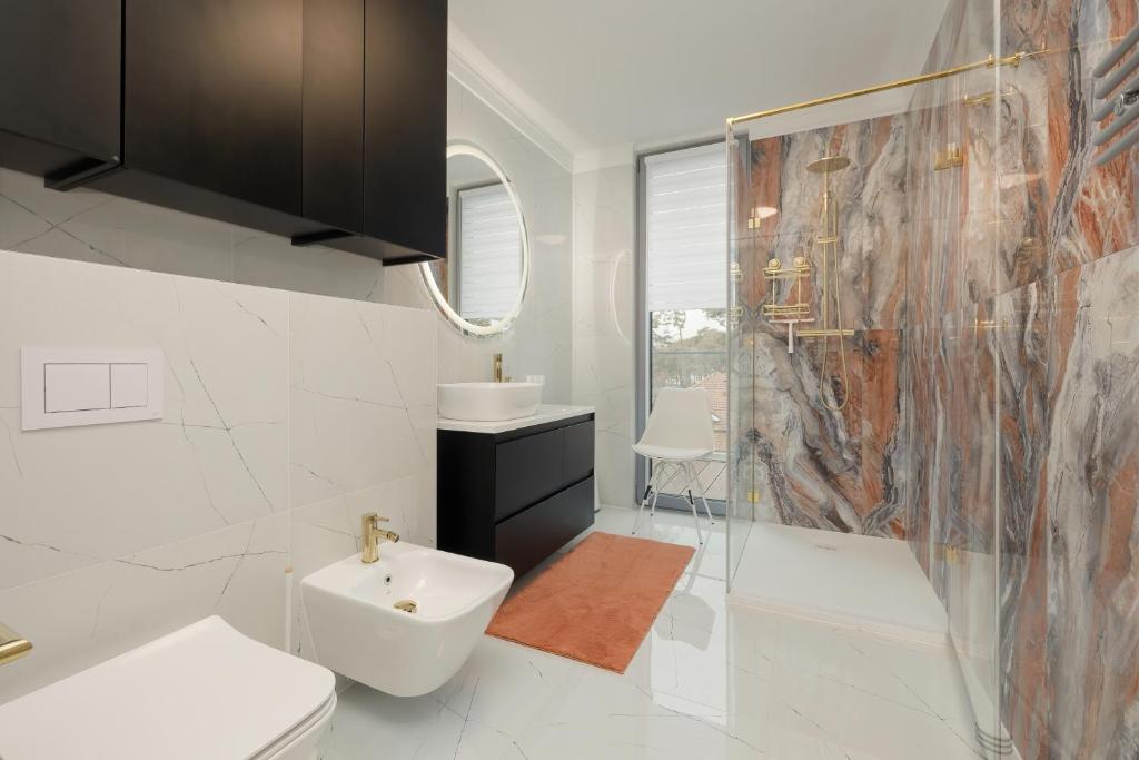 łazienka z toaletą, umywalką i prysznicem w obiekcie Sea&Sky View Apartment Par La Mer w mieście Niechorze
