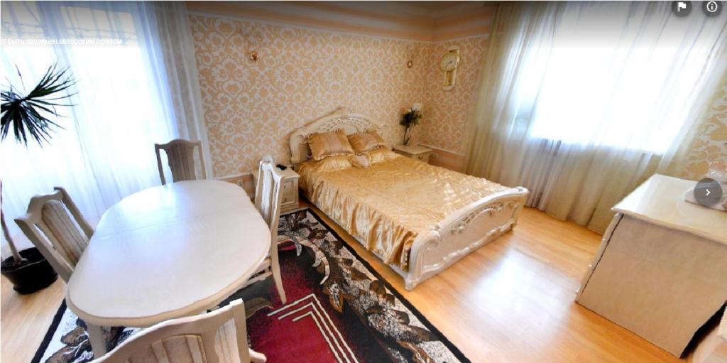 a bedroom with a bed and a table and a table and chairs at Готель Поділля in Shestakovka