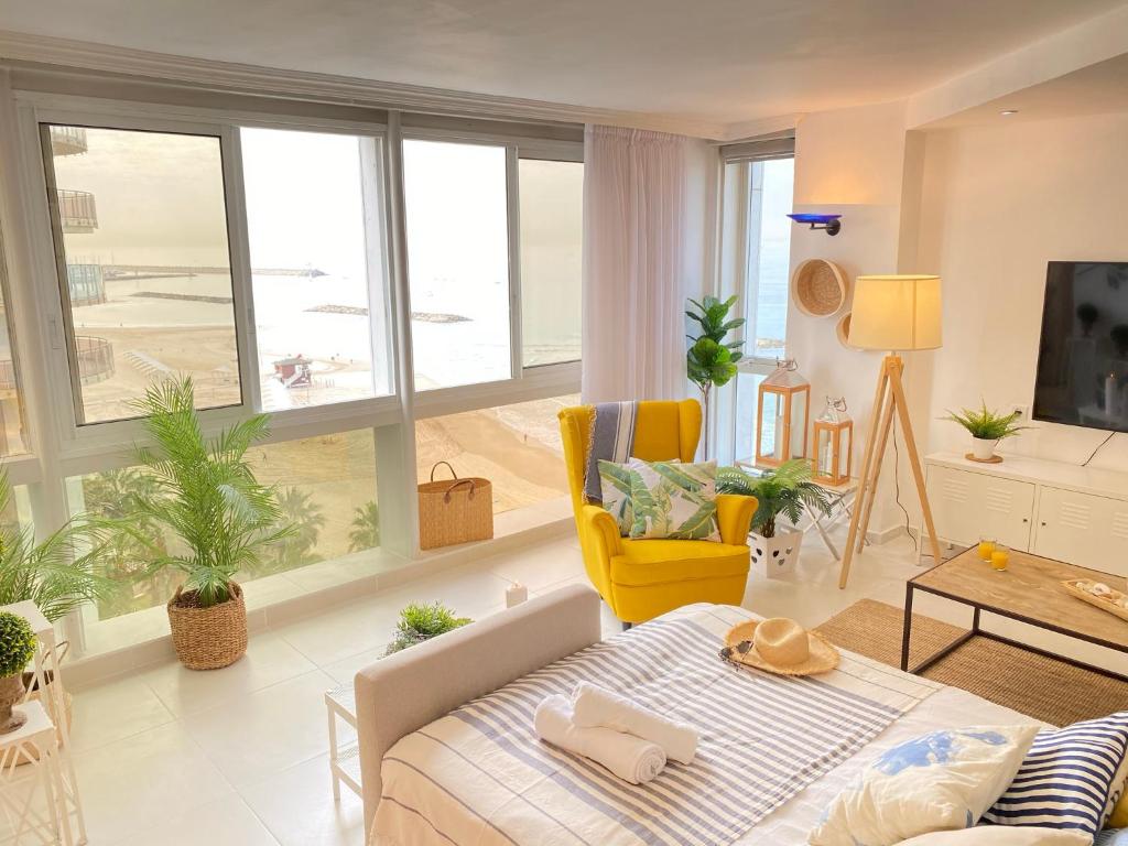 a living room with a bed and a large window at Daniel Beachfront in Herzliya B