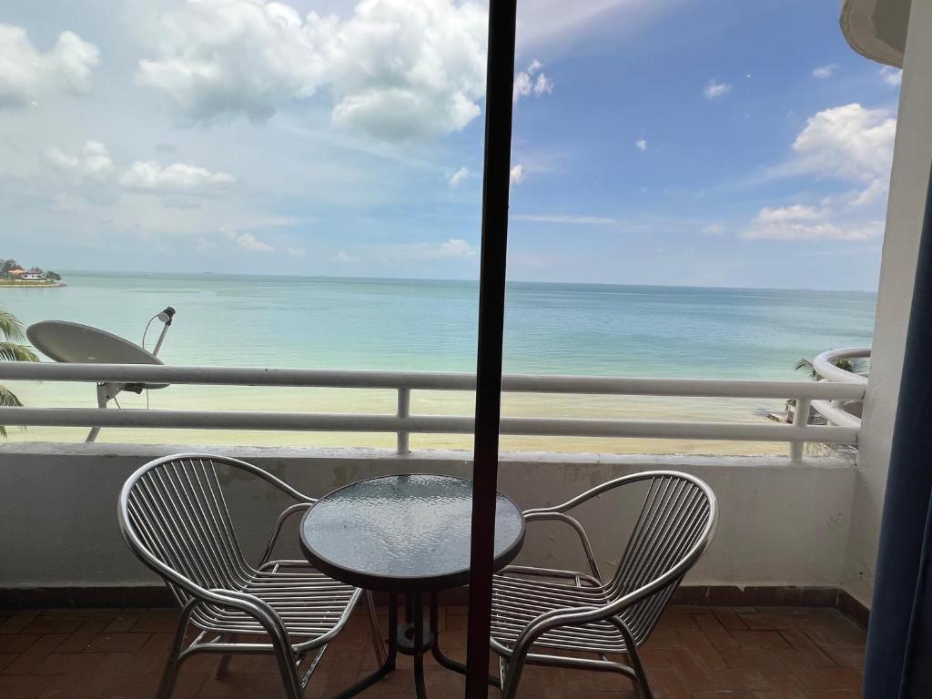 a table and chairs on a balcony with a view of the ocean at Tanjung Tuan Regency Port Dickson 1 CarPark in Port Dickson