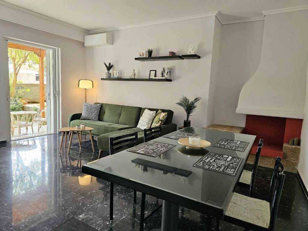 a living room with a table and a green couch at Modern Garden View Apt in Voula, Athens - Luxe in Athens
