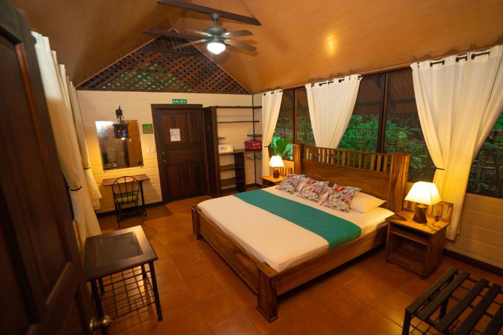 a bedroom with a bed and a ceiling fan at Aninga Lodge in Tortuguero