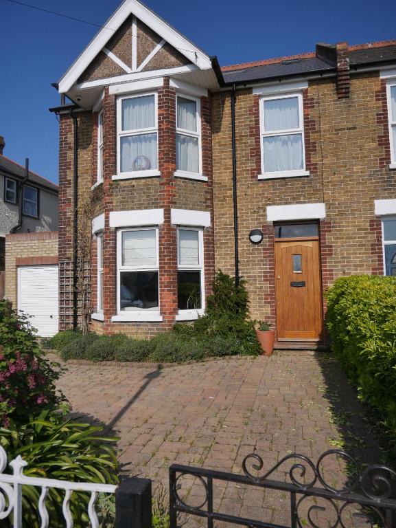 une maison en briques avec une porte en bois dans une allée en briques dans l'établissement Close to beaches and town, off street parking, à Kent