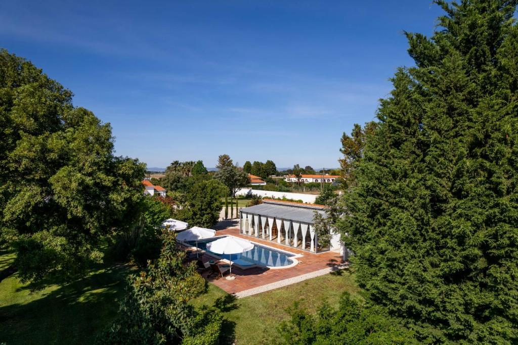 uma vista superior de uma casa com piscina e árvores em Sete Quintas Country House em Salvaterra de Magos