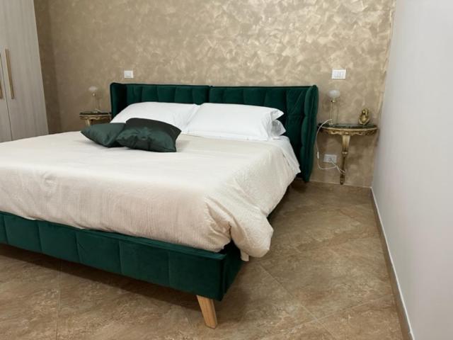 1 dormitorio con 1 cama verde con 2 almohadas en ComfortHouse Garden, en Ladispoli