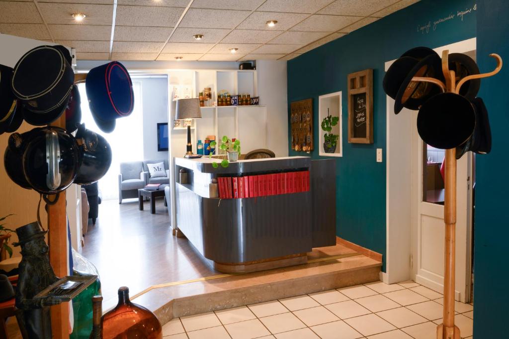 a restaurant with a bar with cowboy hats on the wall at Hotel La Chope in Cambrai