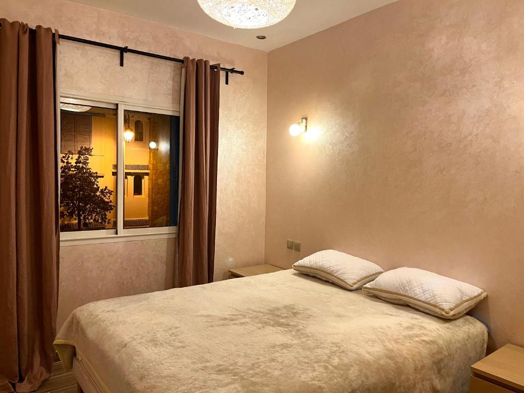 a bedroom with a large bed and a window at Appartement Lilia, Mdiq - Tout confort in M'diq