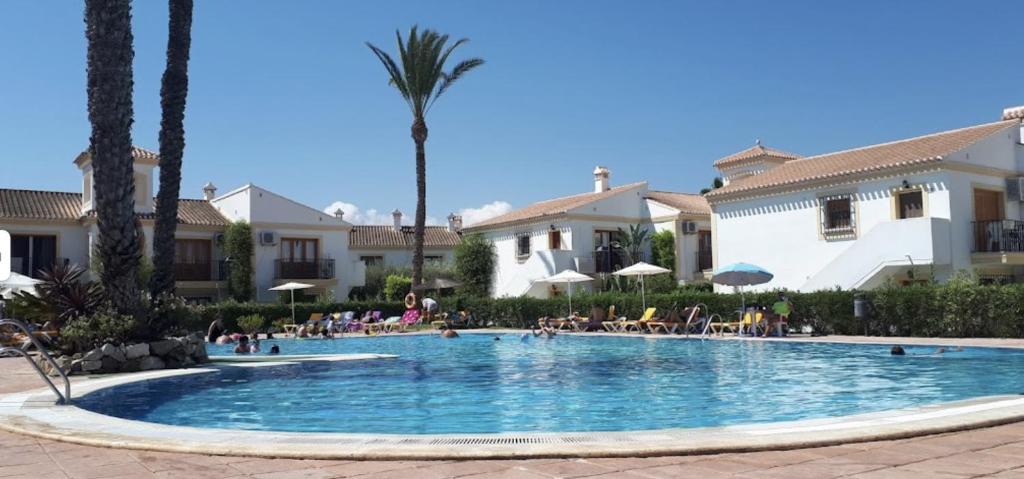 una piscina in un resort con palme di Apartamento 70 Vera Playa a Vera