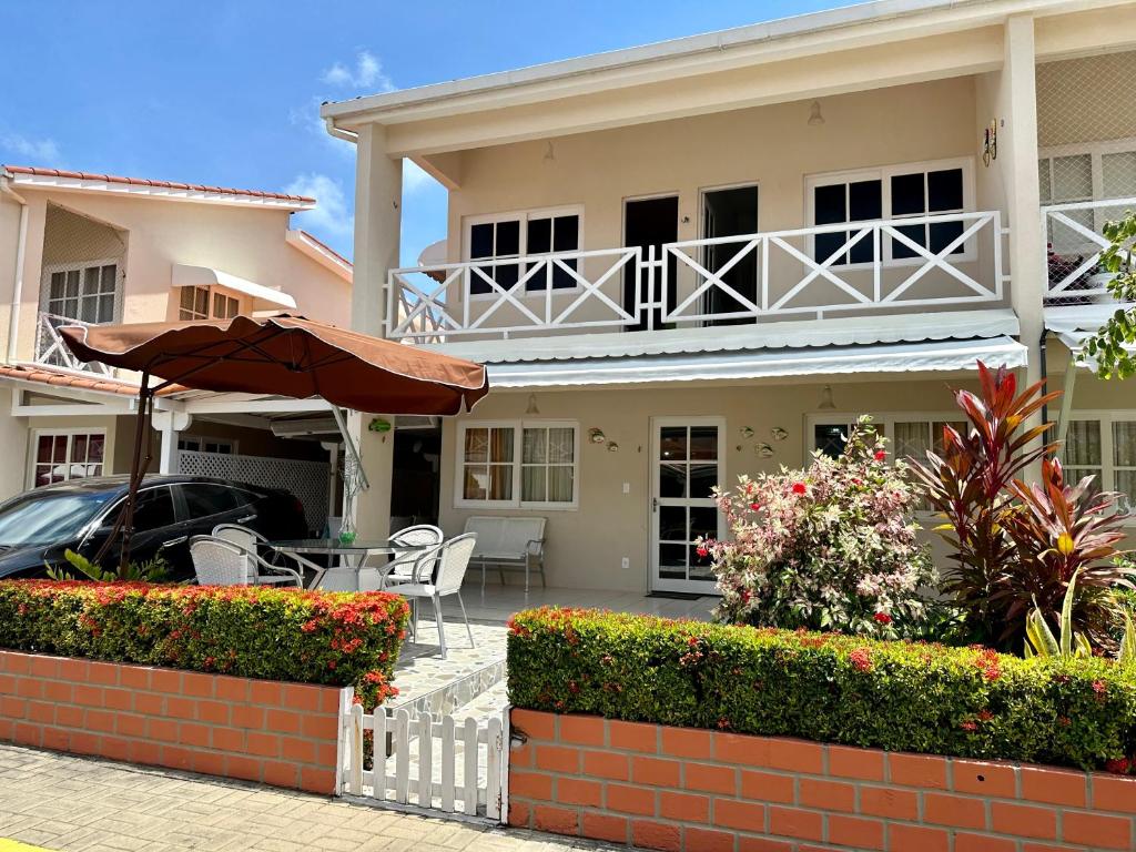 保利斯塔的住宿－Casa Beira Mar Melhor Condomínio，一个带遮阳伞和桌椅的房子