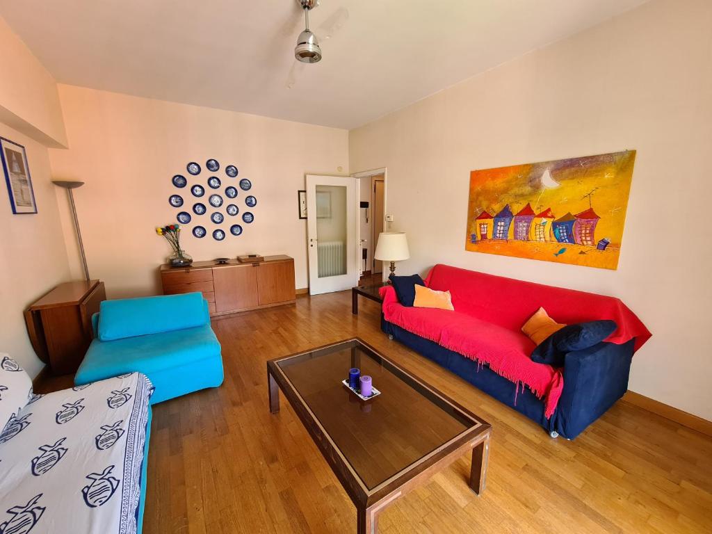 ein Wohnzimmer mit einem roten Sofa und einem Tisch in der Unterkunft La Casa di Barbara By PortofinoVacanze in Santa Margherita Ligure