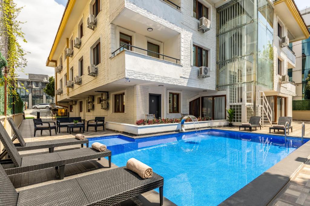 ein Schwimmbad in der Mitte eines Gebäudes mit Bänken in der Unterkunft Baymari Suites Design Florya in Istanbul