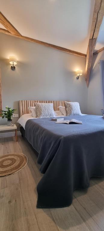 una camera da letto con un letto grande con una coperta blu di Annexe du Moulin Renaudiots - Havre de paix Luxe et Nature ad Autun